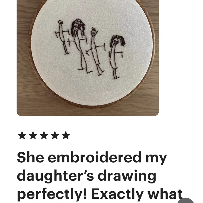 Child's stick-figure family drawing hand-embroidered on dark fabric hoop