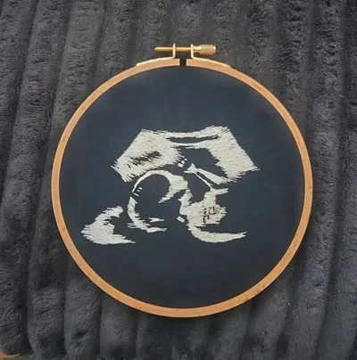 Ultrasound embroidery keepsake stitched in white thread on black fabric